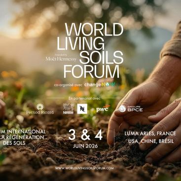 Des mains plantent des jeunes pousses dans un sol fertile, illustrant la régénération des sols, avec le titre “World Living Soils Forum”